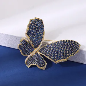Dettaglio spilla farfalla vintage squisita, placcata in oro con zirconi blu brillanti.