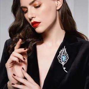 Detail view of vintage silver feather crystal brooch worn on elegant black blazer lapel.