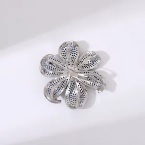 Vue détaillée du dos d'une broche fleur exquise avec des pierres bleues micro-serties.