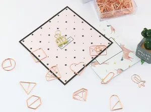 Detailaufnahme roségoldener, geformter Büroklammern, niedliche Lesezeichen für den Schreibtisch.