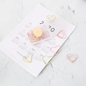 Creative heart-shaped metal paper clips in pink and gold with a clear storage box.
