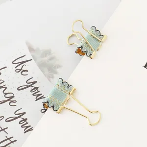 Close-up detail of decorative metal binder clips with elegant blue lace trim for journaling.