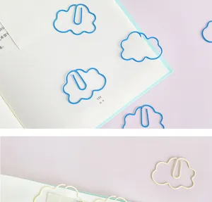 Close-up of cute cloud-shaped paper clips in blue and beige, ideal for book marking and office use.