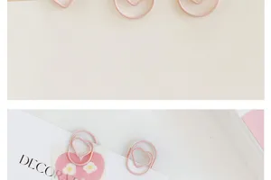 Close-up detail of cute pink heart-shaped paper clips, mini PET coated stationery for planner decor.