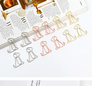 Close-up of cute dog-shaped metal paper clips in gold, silver, and rose gold colors.