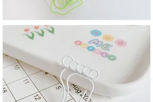 Close-up detail of cute shaped metal paper clips in hand and foot designs on clean desk.