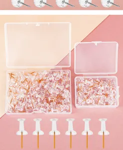 Transparent pushpins with gold needles in clear plastic storage boxes, ideal for corkboards.