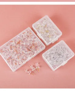 Transparent plastic storage boxes filled with assorted pushpins for office corkboard use.