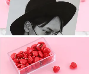 Close-up of cute pink heart-shaped pushpins in a clear plastic box for cork boards.