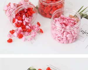 Primo piano di simpatiche puntine a forma di cuore in barattoli trasparenti, dettagli colorati.