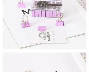 Dettaglio di fermagli per carta viola a stella, clip metalliche in scatola trasparente.