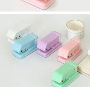 Detail view showing pastel mini metal hole punchers with translucent base for paper binding.