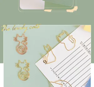 Close-up of cute cat-shaped metal paper clips in gold, ideal for stationery decor.