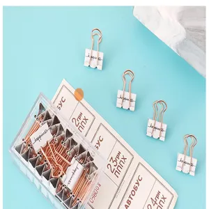 Vista detallada de mini clips de papel blancos y oro rosa de 19mm, pinzas metálicas.