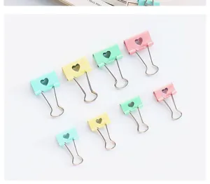 Colorful pastel binder clips with cute heart cutout design, metal office stationery clamps.