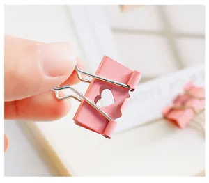 Pink metal binder clip with cute heart cutout detail, perfect for office and school stationery.