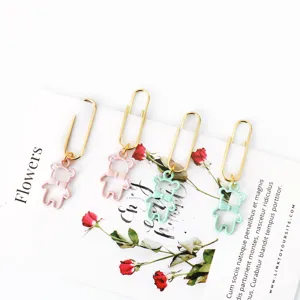 Close-up detail of cute metal bear paper clips with bow tie pendants in pastel colors.