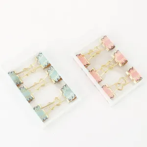 Detail view of creative metal binder clips with lace bows, cute stationery for office and journal.