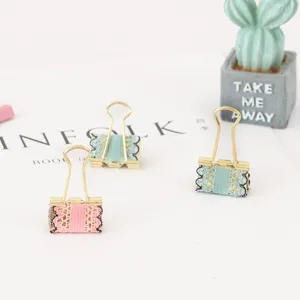 Detailed view of colorful lace binder clips, decorative metal stationery for office and journaling.