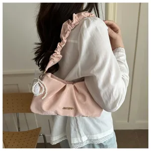 Detail view of pink pleated underarm shoulder bag featuring elegant pearl and lace decoration.