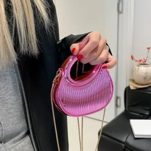 Sac de selle métallique rose avec rayures verticales élégantes et chaîne dorée.