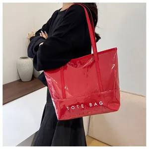 Detailansicht der roten Lackleder-Tragetasche mit klarer Materialtextur und Frontdruck.