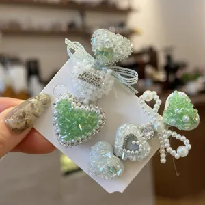 Pince à cheveux cœur strass vert menthe avec perles blanches et détail nœud pour style doux.