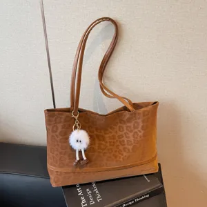 Braune Leopardenmuster Tasche Detailansicht mit weicher Wildleder Textur und dem putzigen Anhänger.