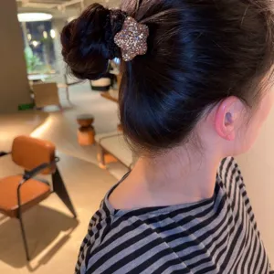 Détail chouchou cheveux étoile strass, attache queue de cheval noire élégante pour chignon.