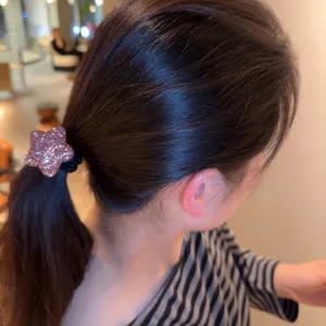 Gros plan détaillé d'un élastique à cheveux en forme d'étoile rose strassée très élastique.