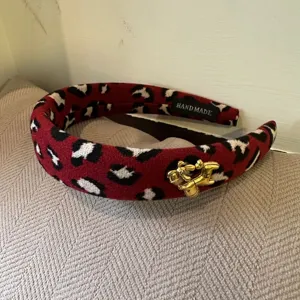 Red leopard print tweed headband with gold horse charm, thick winter hair hoop accessory.
