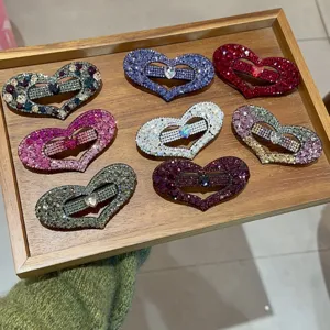 Vue détaillée de pinces à cheveux cœur en strass scintillants de diverses couleurs, élégantes.