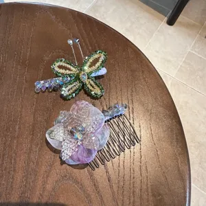 Detailed shot of handmade crystal beaded butterfly hairpin and purple flower hair comb set.