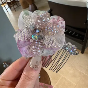 Crystal flower hair comb detail shot, sparkling bead floral design with sheer fabric layers.