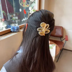 Vue détaillée d'un peigne à cheveux papillon en strass étincelant avec des perles fines et un éclat.