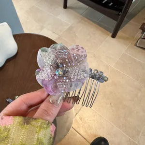 Detailed close-up of sparkling crystal beaded flower hair comb, elegant floral side insert design.
