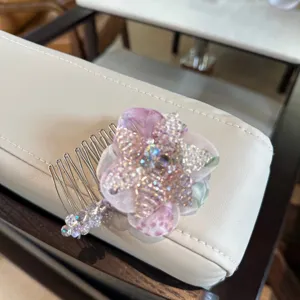 Close-up detail of the crystal flower hair comb, showing sparkly beads and delicate purple petals.