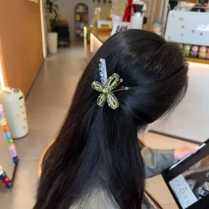 Detail shot of a beaded crystal flower hair clip worn in hair, elegant and sparkling.