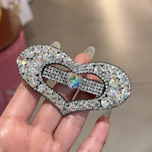 Vue détaillée de pince à cheveux cœur en strass étincelant avec cristal coloré au centre.