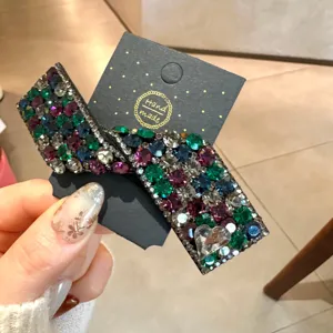 Détail exquis de pince à cheveux nœud strass, cristaux colorés étincelants sur carte.