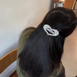 Vue détaillée d'une pince à cheveux cœur en strass brillants, élégante barrette pour demi-queue.