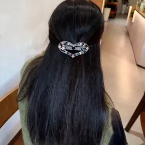 Détail de pince à cheveux cœur en strass exquis, cristaux scintillants et design élégant.