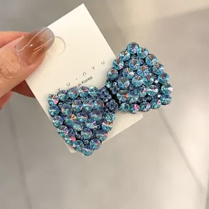 Gros plan de la pince à cheveux nœud en strass bleus étincelants avec un savoir-faire exquis.