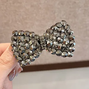 Gros plan de la pince à cheveux nœud en strass scintillants, accessoire épingle cloutée