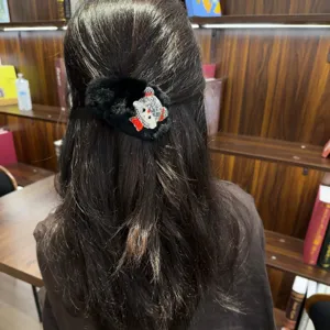 Λεπτομερής όψη μαύρου βελούδινου κλιπ μαλλιών με λαμπερά στρας, γλυκό καθημερινό στιλ.
