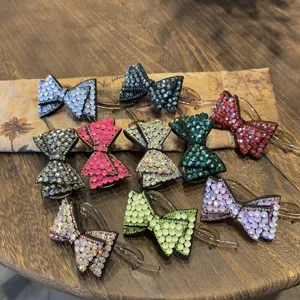 Vue détaillée de pinces à cheveux nœud en strass étincelant, présentant diverses couleurs.