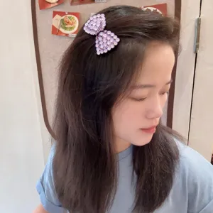 Gros plan détaillé d'une pince à cheveux nœud strass violet scintillant, accessoire élégant.