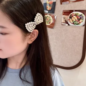 Vue détaillée d'une pince à cheveux nœud strass scintillante, design élégant pour coiffure.