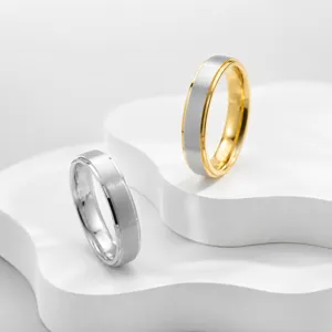 Anillos de pareja cepillados de acero inoxidable, vista detallada con bandas texturizadas.