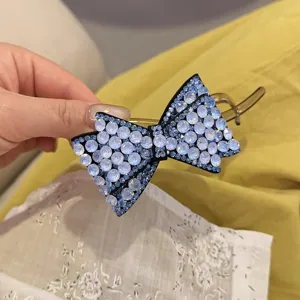 Détail pince à cheveux nœud strass, design cristal bleu étincelant, accessoire de coiffure élégant.